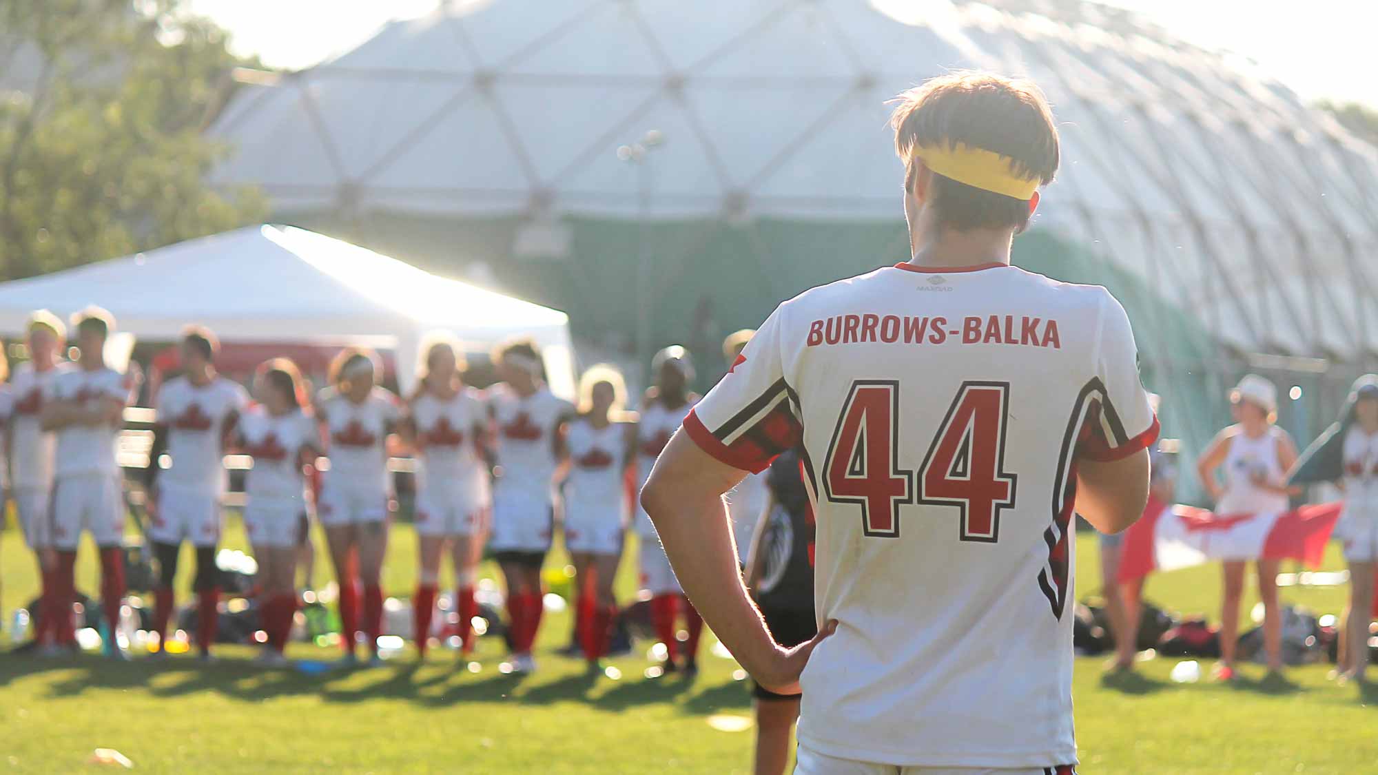 Photo of Quidditch Canada player in light jersey from the back.